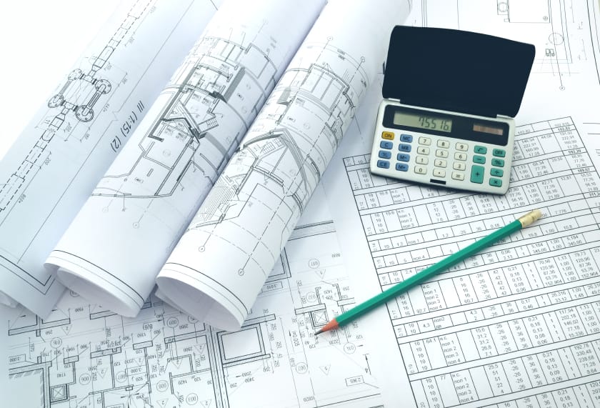 Byggritningar med kalkylator och penna vid projektplanering