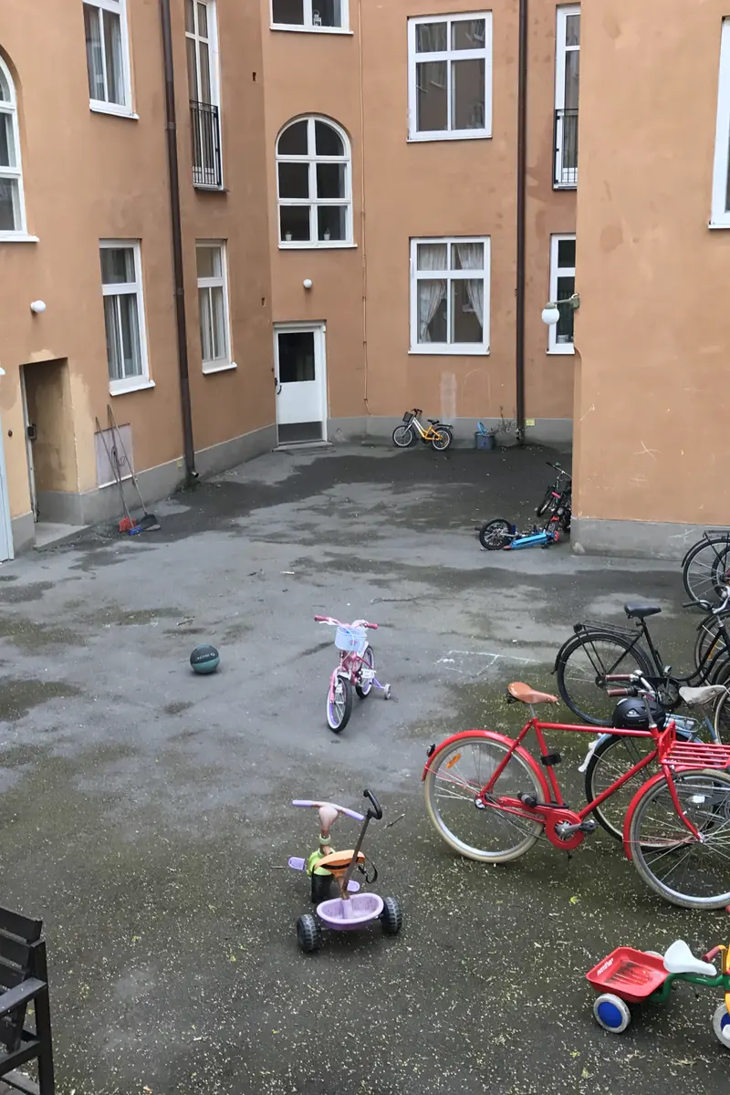 Innergård före renovering med asfalterad gårdsyta och cyklar