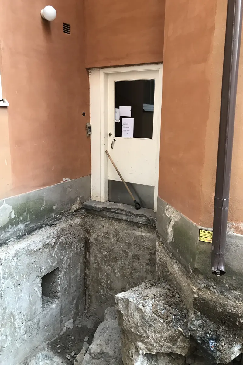 Öppnat gårdsbjälklag intill entrén vid utredning av tätskikt