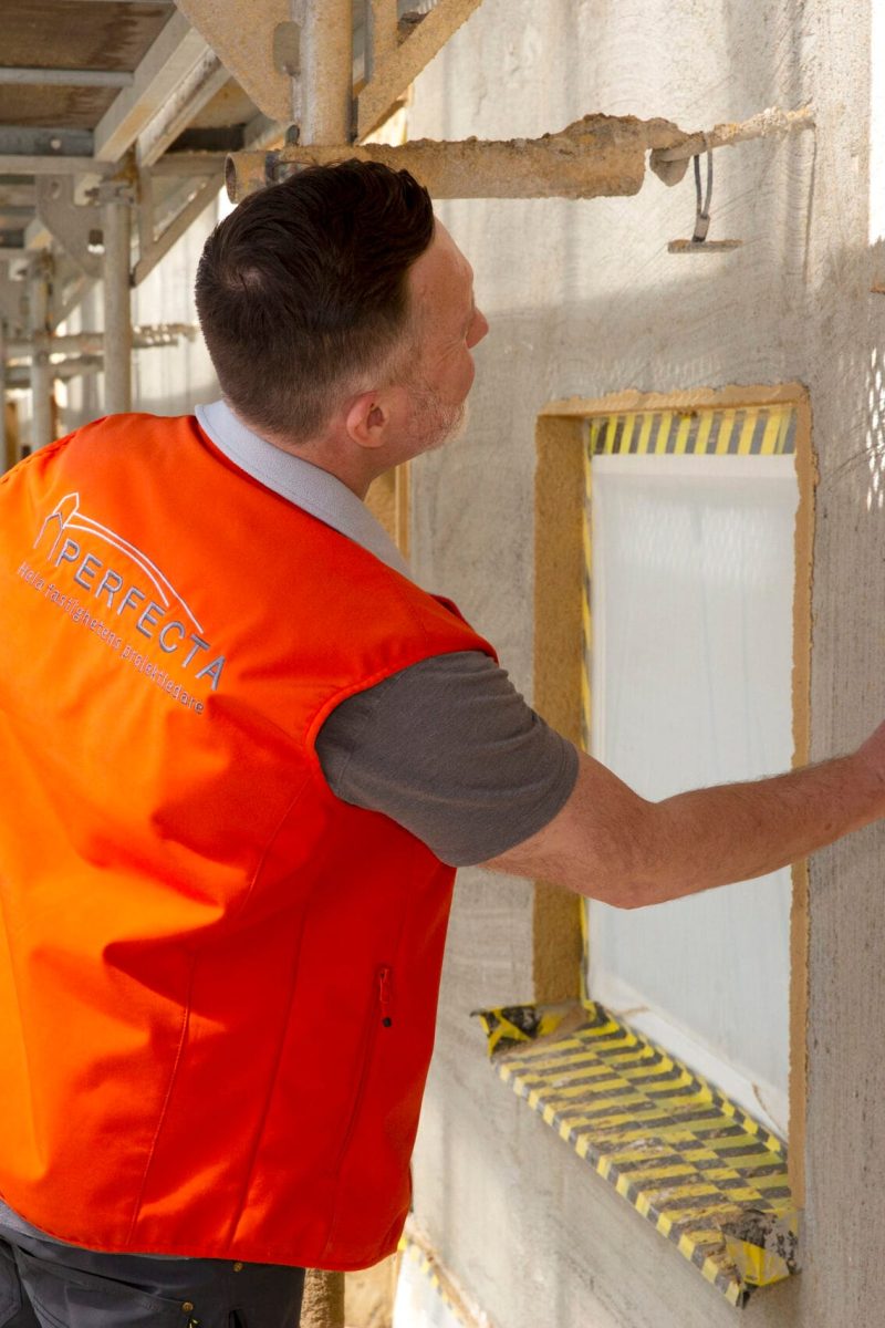 Byggnadsarbetare utför fasadrenovering och fasadputs i Stockholm