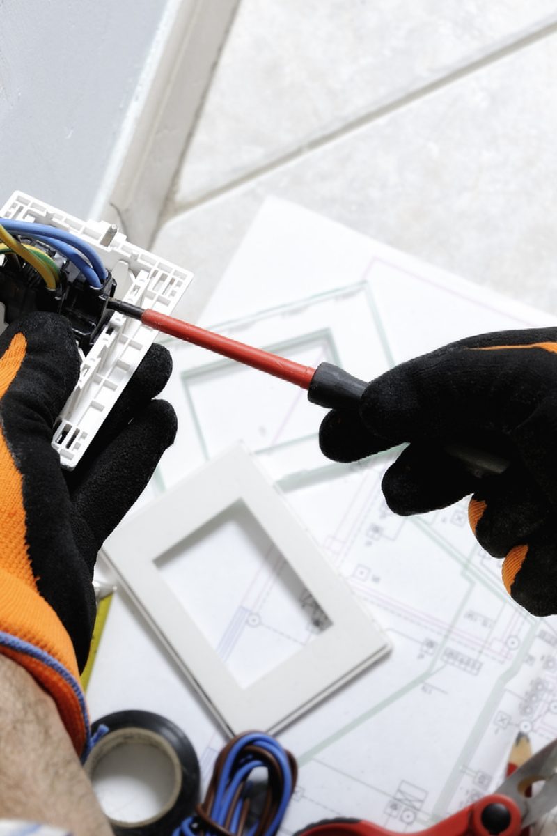 Electrician working safely on switches and sockets of a residential electrical system