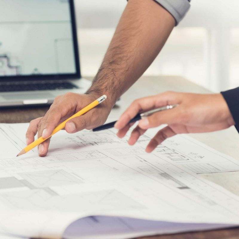 Projektledare och klient granskar byggritningar vid projektplanering