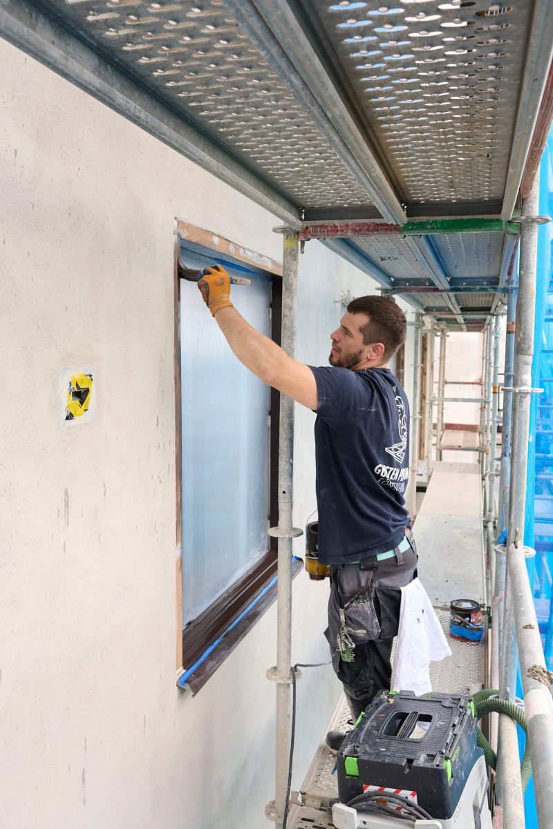 Hantverkare renoverar fönster i bostadsrättsförening från insidan