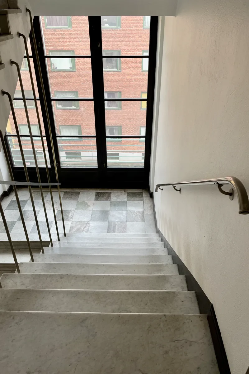 Renoverat trapphus i Stockholm med marmortrappa, mässingsräcke och handledare